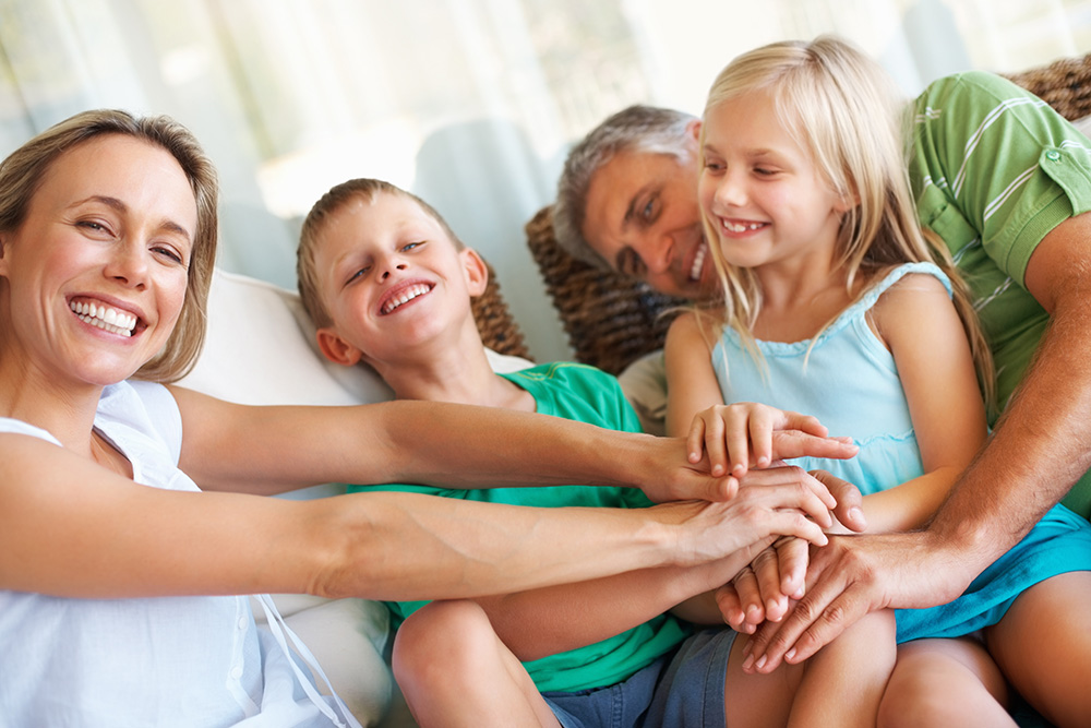 Portrait of family keeping their hands one another at home